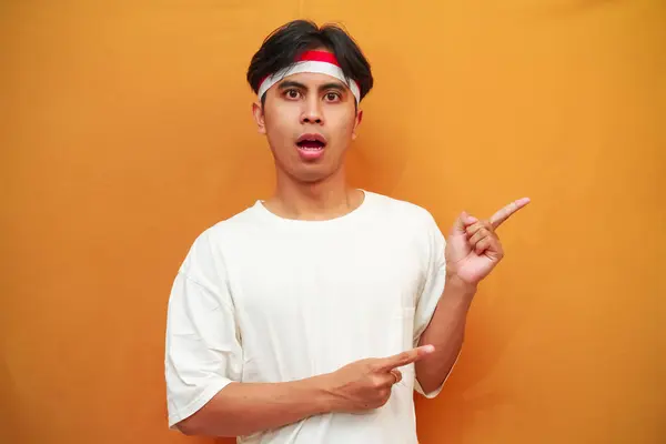 stock image happy Indonesian man celebrating Indonesian independence day on August 17th, wow excited face Indonesian man celebrating Indonesian independence day while pointing with his finger