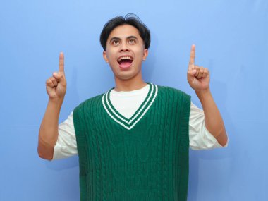 Asyalı bir adamın boş bir telif alanını işaret eden portresi heyecanlı mutlu yüzle izole edilmiş mavi arkaplan.