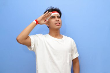 Beyaz tişörtlü Endonezyalı adam ve Endonezya bayrağı gururla selamlıyor, Endonezya bağımsızlık günü konsepti