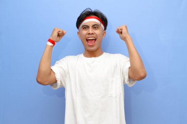 heyecanlı Endonezyalı beyaz gömlekli adam ve Endonezya bayrağı sıkılmış yumruğunu sallarken gururla bağırıyor zafer ve başarıyı kutluyor, Endonezya bağımsızlık günü konsepti