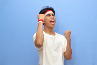 heyecanlı Endonezyalı beyaz gömlekli adam ve Endonezya bayrağı sıkılmış yumruğunu sallarken gururla bağırıyor zafer ve başarıyı kutluyor, Endonezya bağımsızlık günü konsepti