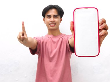 Pembe tişört giyen genç Asyalı bir adam parmağını kaldırırken akıllı telefon ekranı gösteriyor. Bir numara, beyaz izole bir arka planda dostça bir gülümsemeyle..