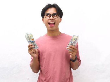 Pembe gömlekli genç bir Asyalı 'nın portresi. Elinde para tutuyordu. Beyaz arka planda düşünceli bir ifadeyle yukarı bakıyordu.