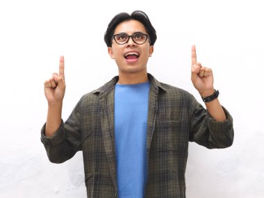 Mavi tişörtlü genç Asyalı adam boş fotokopi alanını gösteriyor. Promosyon veya reklam içeriği için ideal..