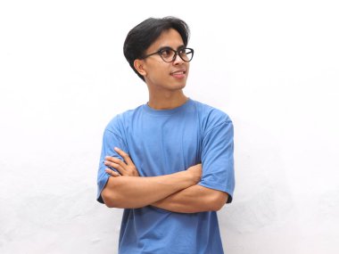 Gülümseyen, mavi tişörtlü, kolları çapraz duran, beyaz arka planda yalnız, kendinden emin, Asyalı genç bir adam.