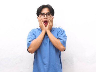 Şok olmuş ve kameraya bakan Asyalı adamın portresi. Soldaki boş alana bakan Asyalı adam şok oldu. Şaşırmış ve şok olmuş Asyalı bir adam gibi hissediyor. Şaşırmış ifadesi olan Endonezyalı adam..