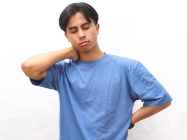 Stresli Asyalı genç adam beyaz arka planda mavi tişört giyiyor..