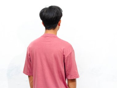 Pembe tişört giyen genç bir Asyalı 'nın beyaz arka planda duruşu. Reklamlar ve pazarlama için mükemmel..