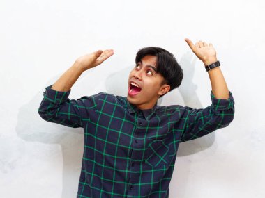 Genç bir Asyalı kafasında fotokopi alanı olan beyaz bir arka planda izole edilmiş bir şey taşıyor..