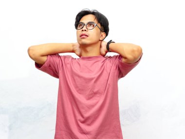 Pembe tişörtlü genç bir Asyalı 'nın portresi, beyaz bir arka plana karşı stresli ve hayal kırıklığına uğramış bir ifade gösteriyor..