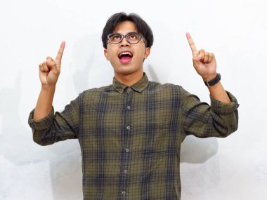 Yakışıklı, Asyalı genç bir adamın portresi beyaz bir arkaplanı işaret ediyor, coşku ve pozitiflik gösteriyor, reklam amaçlı ideal..