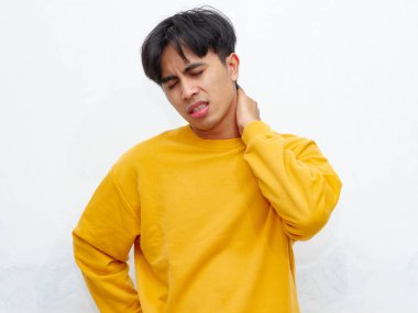 Boynunu tutarak acı ve üzüntü gösteren sağlıksız bir Asyalı adamın portresi. Beyaz bir arka planda izole edilmiş. Sağlık, tıbbi ya da acıyla ilgili kavramlar için mükemmel.