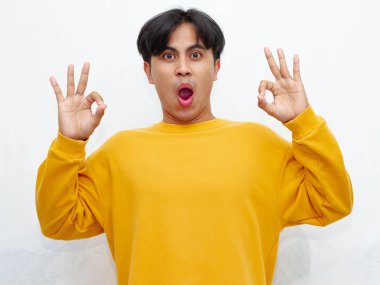 Asyalı bir adamın portresi beyaz arka planda izole edilmiş komik bir ifadeyle el hareketi yapıyor. Çeşitli medyada reklamcılık ve kültürel temsil için mükemmel..