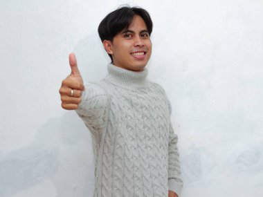 Mutlu gülümseyen Asyalı bir adamın portresi, beyaz bir arka planda güvenle ayakta duruyor. Reklamlar, promosyonlar ve pazarlamada olumlu kavramlar için mükemmel..