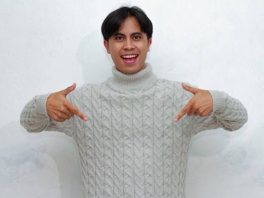 Mutlu ve heyecanlı Asyalı bir adamın portresi beyaz arka planda izole edilmiş bir reklam sunmak için aşağıya bakıyor. Reklam ya da terfi için mükemmel..