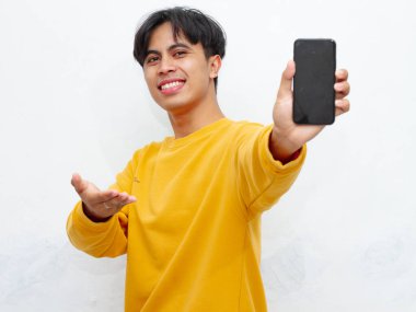 Beyaz arka planda boş ekranlı akıllı telefon gösteren heyecanlı Asyalı genç adam