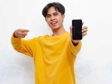 Beyaz arka planda boş ekranlı akıllı telefon gösteren heyecanlı Asyalı genç adam