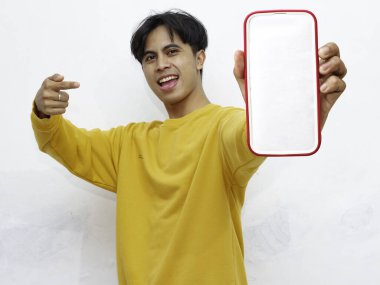 Beyaz arka planda boş ekranlı akıllı telefon gösteren heyecanlı Asyalı genç adam