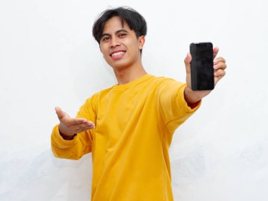 Beyaz arka planda boş ekranlı akıllı telefon gösteren heyecanlı Asyalı genç adam