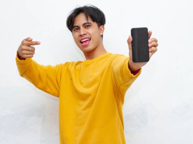 Beyaz arka planda boş ekranlı akıllı telefon gösteren heyecanlı Asyalı genç adam