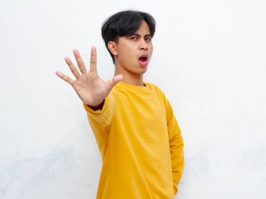 Beyaz arka planda elle izole edilmiş dur işareti yapan Asyalı ciddi bir adamın portresi.