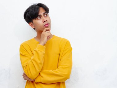 Asyalı bir adamın portresi, düşünceli bir yüz ifadesi, yukarı bakan gözler, ve çene üzerinde dinlenen el, düşüncelere dalmış ya da derin düşüncelere dalmış, beyaz arka planda soyutlanmış.