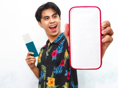 Genç Asyalı 'nın portresi günlük giysiler giyer. Pasaport tutar ve boş cep telefonu ekranı gösterir. Beyaz arka planda izole edilmiş mutlu ekspresyonlar..