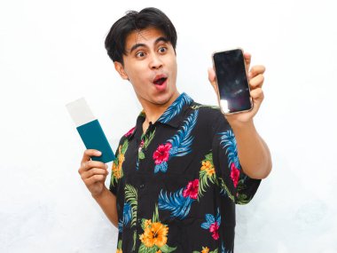 Portrait of Young asian man wear summer casual clothes holding pasport and showing blank mobile phone screen with wow happy exspression isolated on white background. clipart