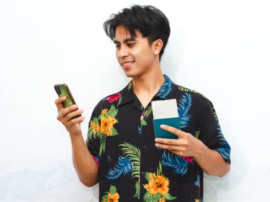 Pasaport tutarken mutlu bir şekilde gülümseyen, günlük kıyafetlerle genç bir Asyalı 'nın portresi. Kaçış için heyecanlanan bir turistin mükemmel bir temsili..