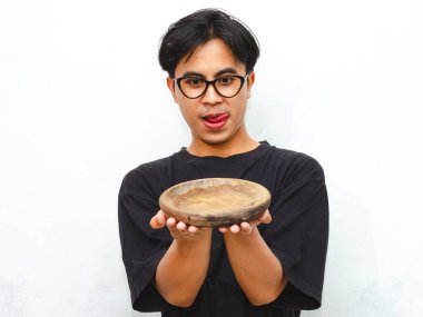 Boş tişört giyen hevesli genç bir Asyalı 'nın portresi beyaz arka planda boş bir tahta tabak gösteriyor, yemek reklamı ya da promosyon için ideal.