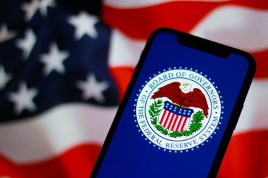 Federal Rezerv Sistemi 'nin logosu, arka planda Amerikan bayrağı olan Fed.