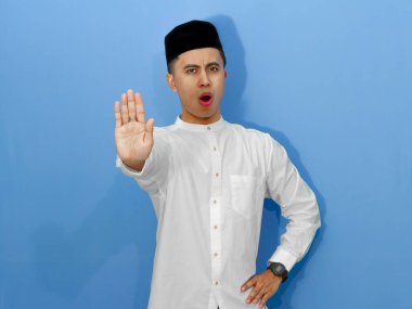 Asyalı genç bir müslüman, dini yaşam tarzı ve sınırları temsil eden bir jest yapıyor. İslami ve kültürel kavramlar için mükemmel..