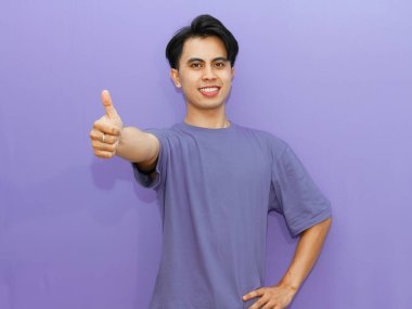 Kendine güveni tam bir Asyalı genç adam gülümsüyor. Mor bir geçmişi var. Reklamcılık için mükemmel..