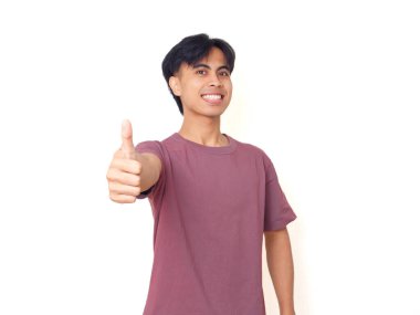 Mutlu, kendine güvenen genç adam kameraya izole edilmiş arka planda iyi niyet göstergesi olarak gülümsüyor. İş, yaşam tarzı ve reklam içeriği için mükemmel..