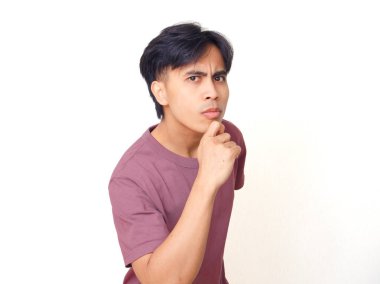 Düşünceli genç Asyalı adamın çenesine garip bir ifadeyle dokunması, beyaz arka planda soyutlanması, düşünme, karar verme ya da reklam fikri..