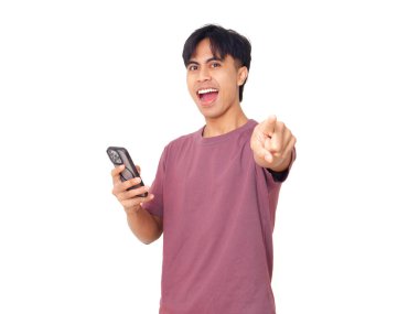 Akıllı telefon tutan genç Asyalı adam izole edilmiş beyaz arka planda kameraya işaret ediyor mobil uygulama tanıtımı, dijital yaşam tarzı ve iletişim.