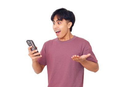 Mutlu Asyalı genç adam akıllı telefonu açık ağızla tutuyor ve elleri kaldırıyor. Heyecanlı, şaşırmış tepkiler gösteriyor..