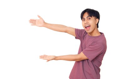 Heyecanlı genç Asyalı adam göstererek ve göstererek göstererek sade arka planda, ürün yerleştirme, pazarlama ve promosyon tasarımı için mükemmel.