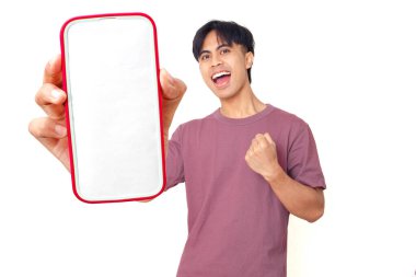 Mutlu Asyalı genç adam kutlarken düz arkaplanda boş akıllı telefon ekranı gösteriyor. Dijital reklam, uygulama tanıtımı ve pazarlama tasarımı için mükemmel..