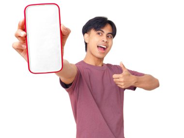 Mutlu Asyalı genç adam boş bir akıllı telefon ekranı göstererek dijital reklamlar, uygulama tanıtımı ve pazarlama tasarımı için mükemmel arka planda başparmak kaldırıyor..