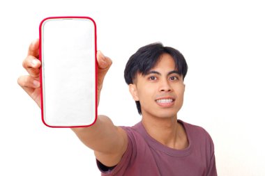 Mutlu Asyalı genç adam boş akıllı telefon ekranını arka planda reklam için gösteriyor pazarlama, uygulama promosyonu ve dijital reklamlar için mükemmel..