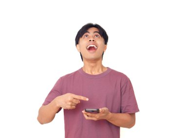 Akıllı telefonu işaret eden mutlu genç Asyalı adam arka planda heyecanlı bir yüz ile dijital reklamlar, uygulama tanıtımı ve çevrimiçi pazarlama için mükemmel..