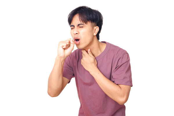 Young Asian man coughing and holding his throat with painful expression, isolated on white background, concept of flu, sore throat, or health problem.