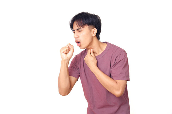 Young Asian man coughing and holding his throat with painful expression, isolated on white background, concept of flu, sore throat, or health problem.