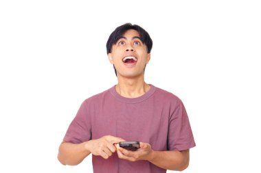 Akıllı telefonu işaret eden mutlu genç Asyalı adam arka planda heyecanlı bir yüz ile dijital reklamlar, uygulama tanıtımı ve çevrimiçi pazarlama için mükemmel..