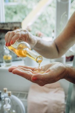 Masaj yağı bir ele damlar ve huzurlu bir rahatlama ve şımartma anı yaratır. Yüksek kalite fotoğraf