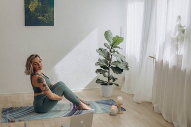 Evde internetten yoga yapan 50 yaşında bir kadın. Yüksek kalite fotoğraf