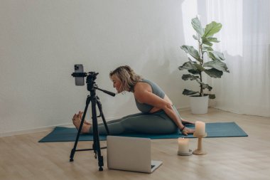 Evde internetten yoga yapan 50 yaşında bir kadın. Yüksek kalite fotoğraf