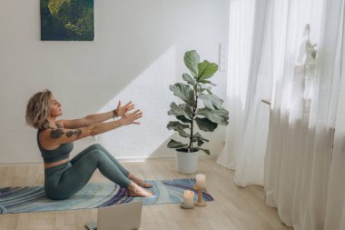 Evde internetten yoga yapan 50 yaşında bir kadın. Yüksek kalite fotoğraf