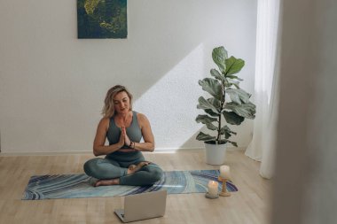 Evde internetten yoga yapan 50 yaşında bir kadın. Yüksek kalite fotoğraf